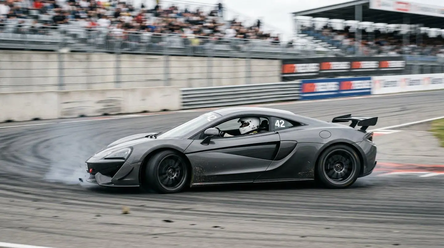 Voiture sportive en action sur circuit avec pilote casqué